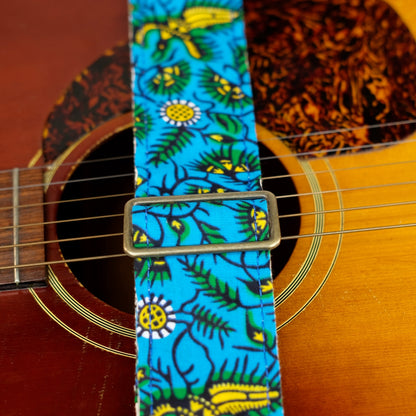 Buckle detail of guitar strap in blue, yellow, and green botanical African wax print fabric with brown leather end-tab. Made in Nashville by Original Fuzz.