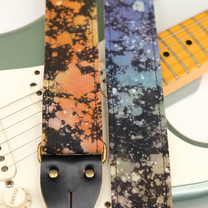 Wide view of guitar strap in multi-colored over black base hand-dyed canvas fabric with black leather end-tab. Made in Nashville by Original Fuzz.