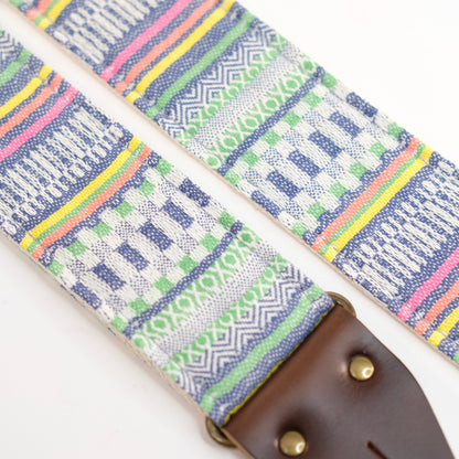 Fabric detail view of guitar strap in white, blue, and green geometric woven fabric with brown leather end-tab. Made in Nashville by Original Fuzz.