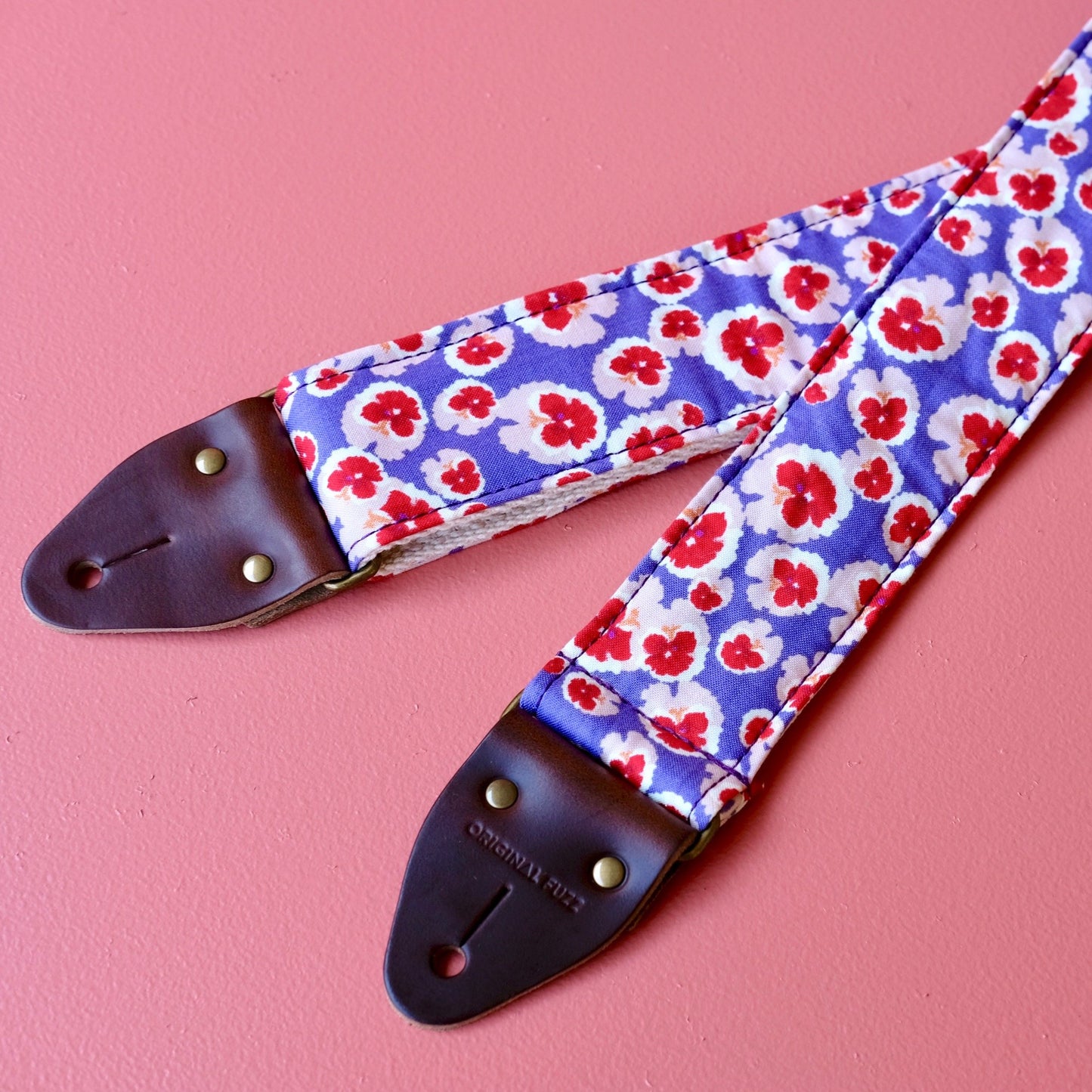 Purple and red classic floral pattern lightweight cotton handmade guitar strap with a Fender guitar. 
