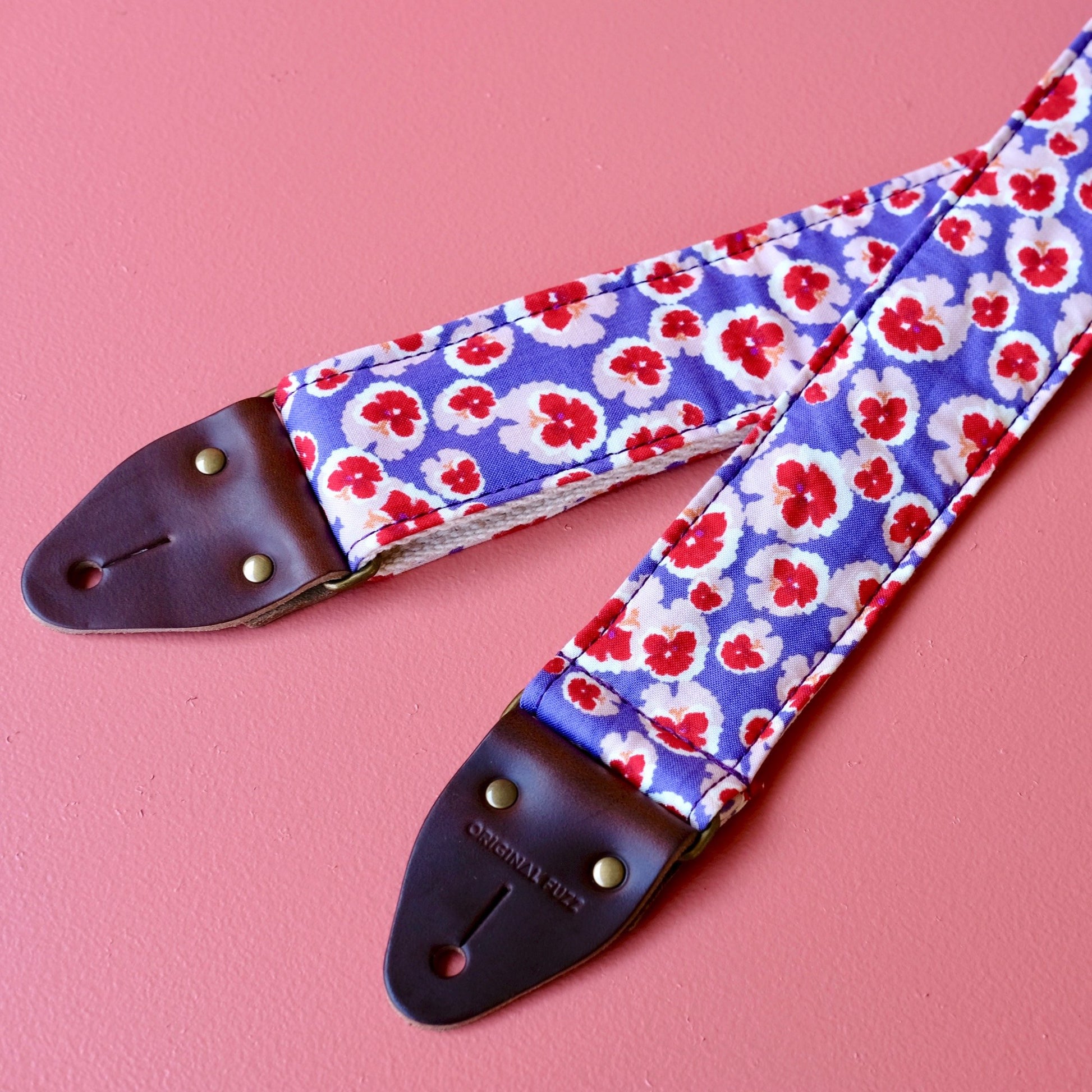 Purple and red classic floral pattern lightweight cotton handmade guitar strap with a Fender guitar. 