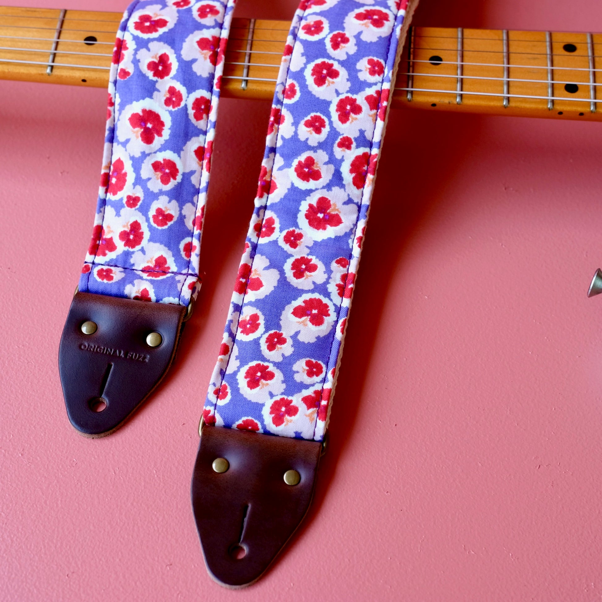 Purple and red classic floral pattern lightweight cotton handmade guitar strap with a Fender guitar. 
