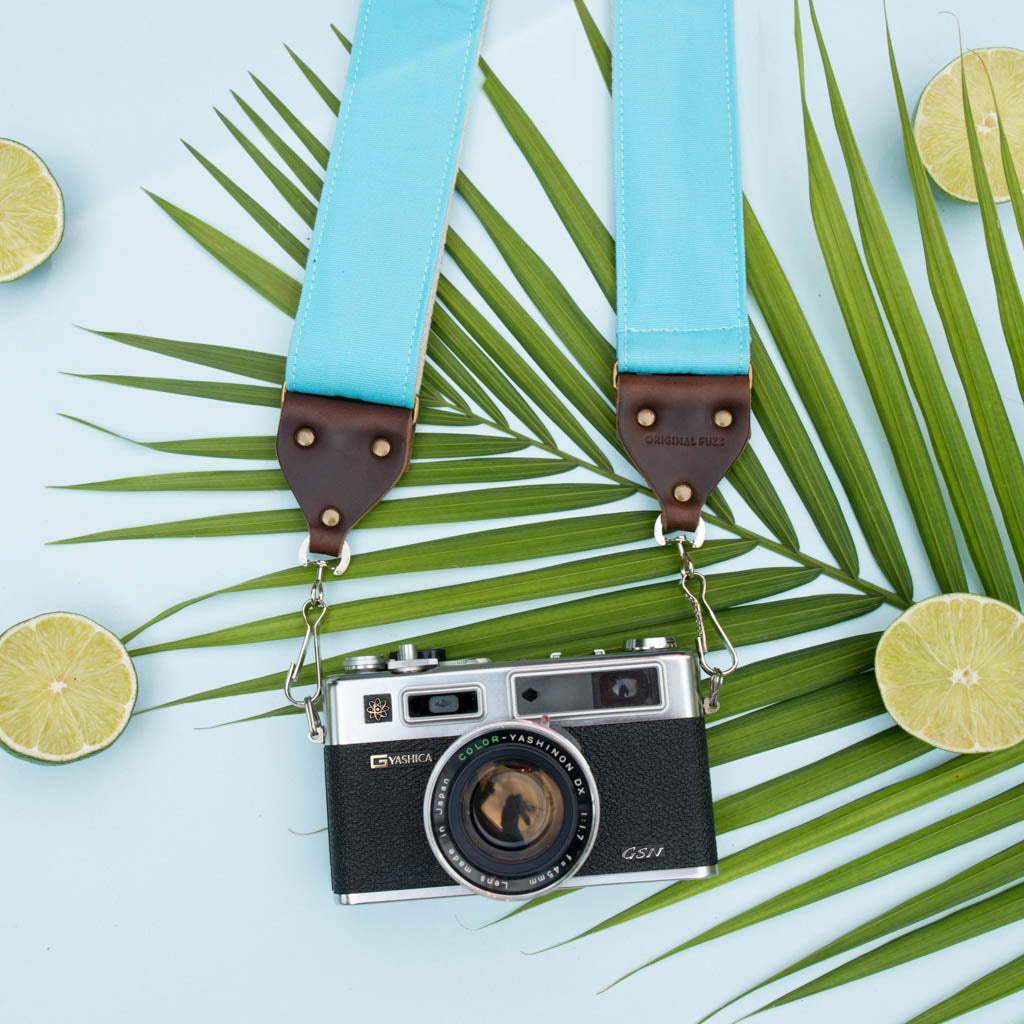 Light arctic blue vintage-style camera strap made by Original Fuzz in Nashville, TN. with a Yashica film camera.