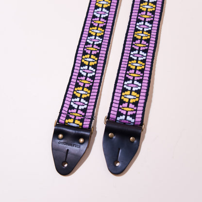 Pink is the predominant color in this vintage woven jacquard guitar strap